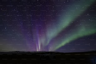 a truck parked in a field under the night sky