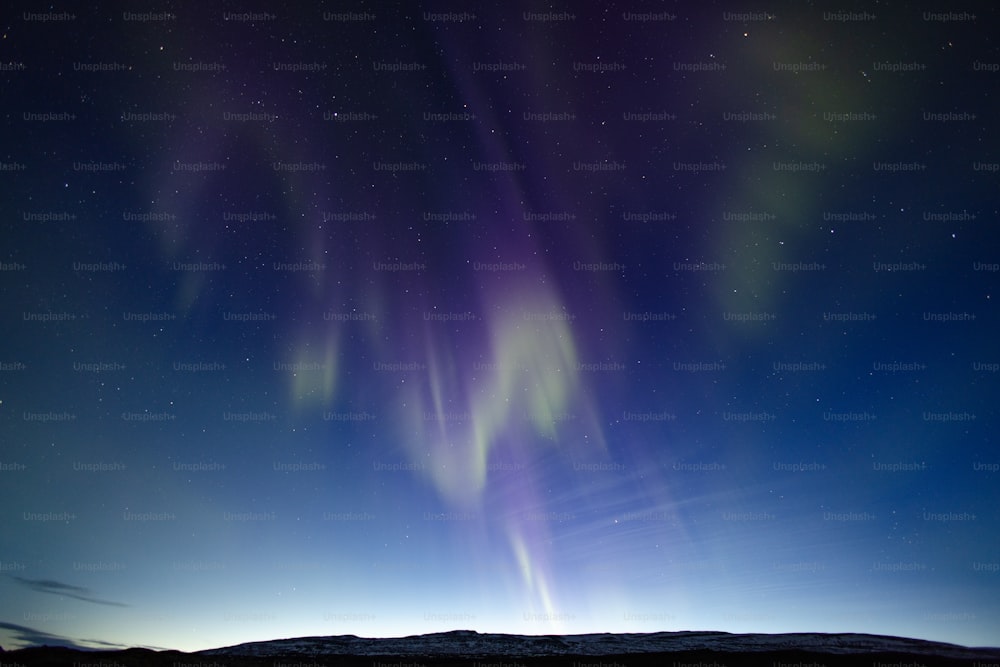 Eine hellviolette und grüne Aurora trug sich am Nachthimmel