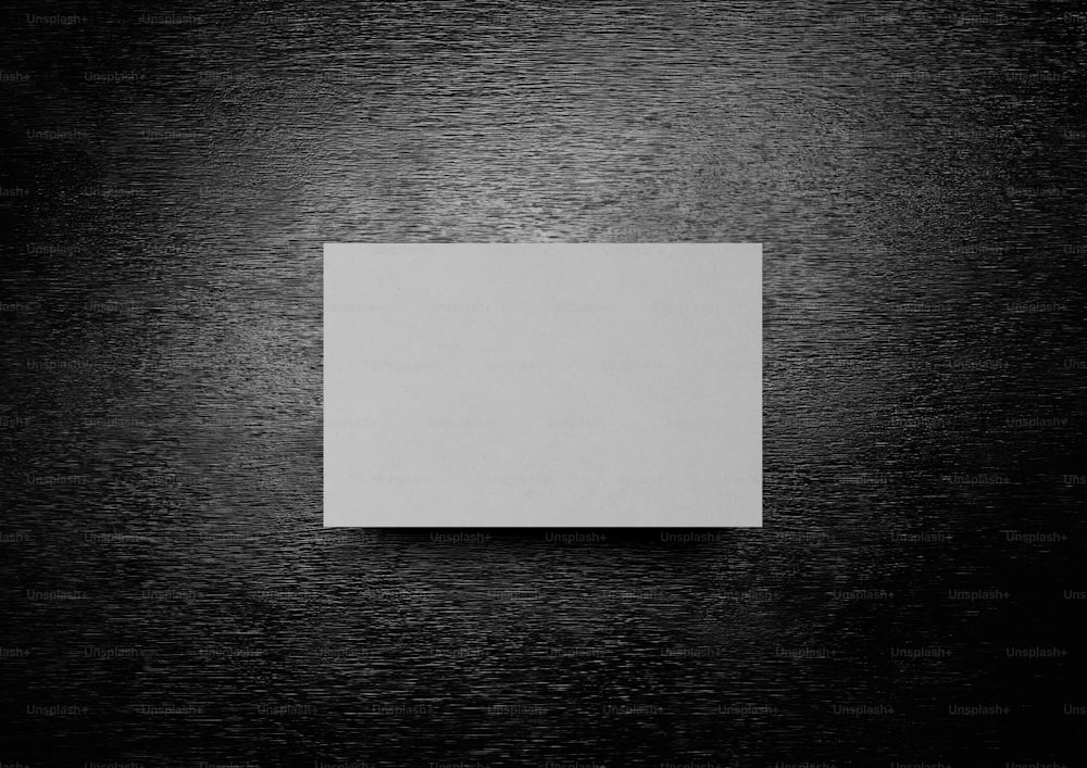 une feuille de papier blanc carrée posée sur une table en bois