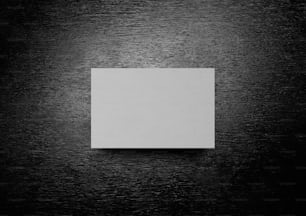 ein quadratisches weißes Blatt Papier, das auf einem Holztisch liegt