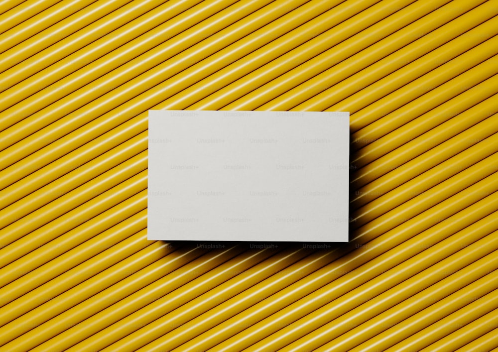 a square white piece of paper on a yellow background