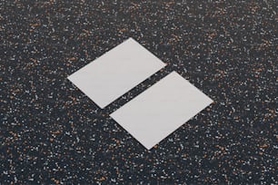 deux morceaux de papier posés sur une surface noire