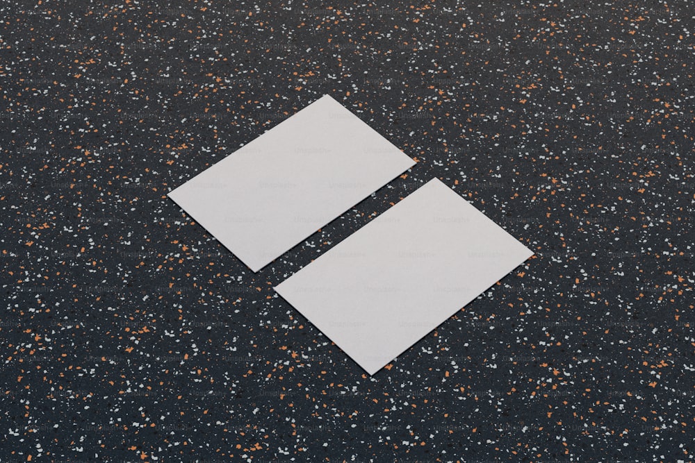 two pieces of paper sitting on top of a black surface