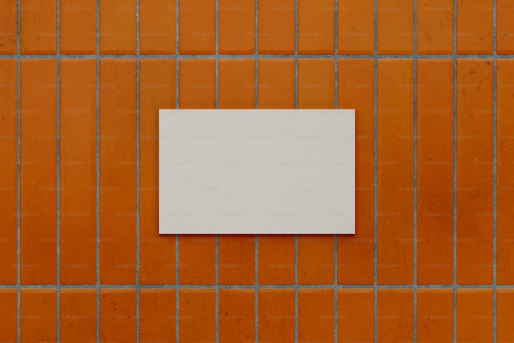 a white piece of paper sitting on top of a tiled wall