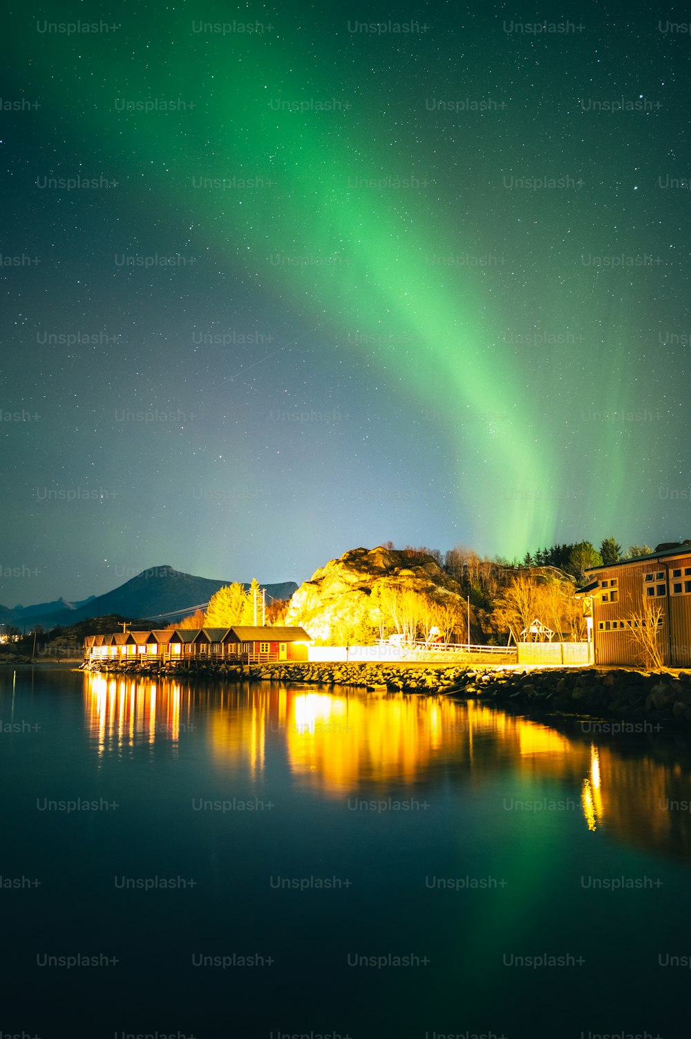 a green and yellow aurora over a body of water