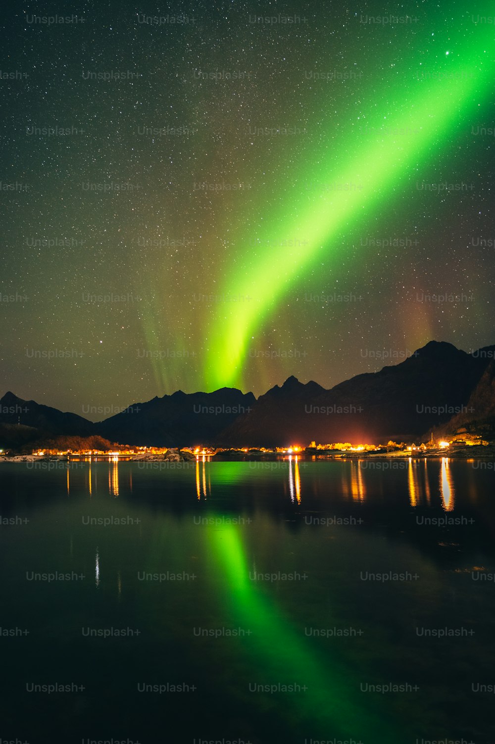 a green aurora bore over a lake at night
