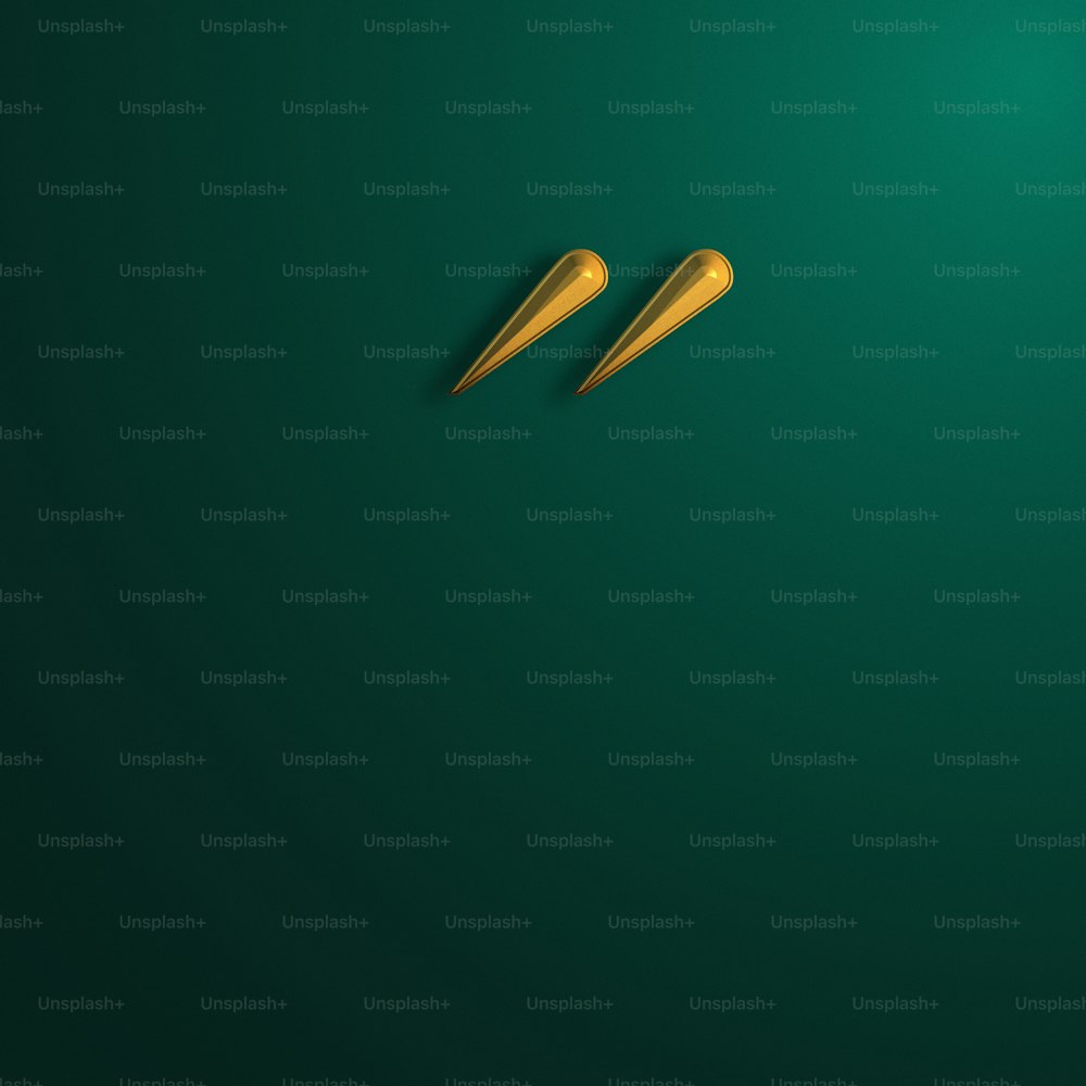 a pair of gold scissors on a green background