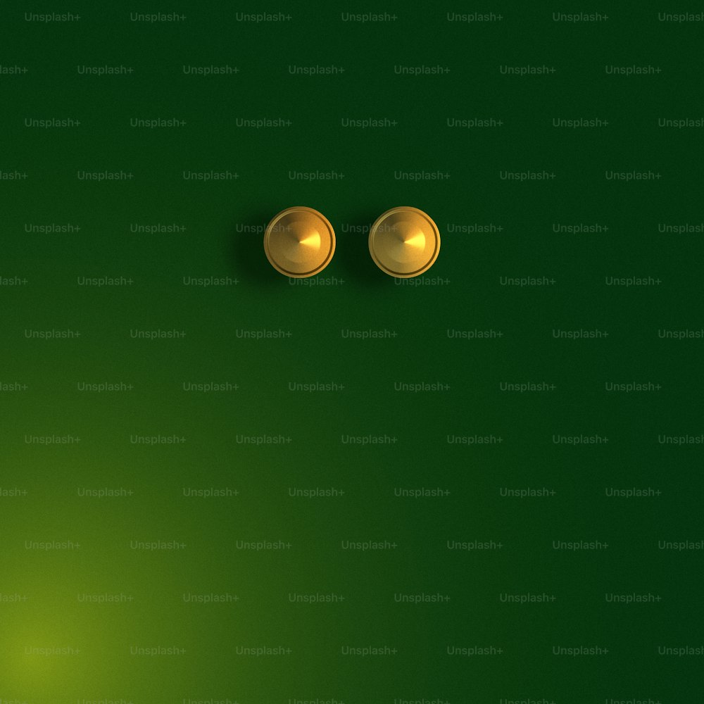 a pair of gold knobs on a green background