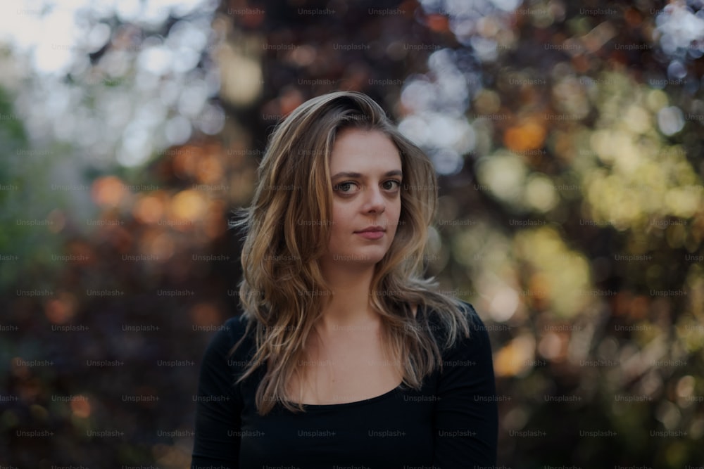 a woman standing in front of a tree