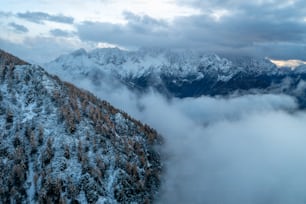 a mountain covered in snow and surrounded by clouds