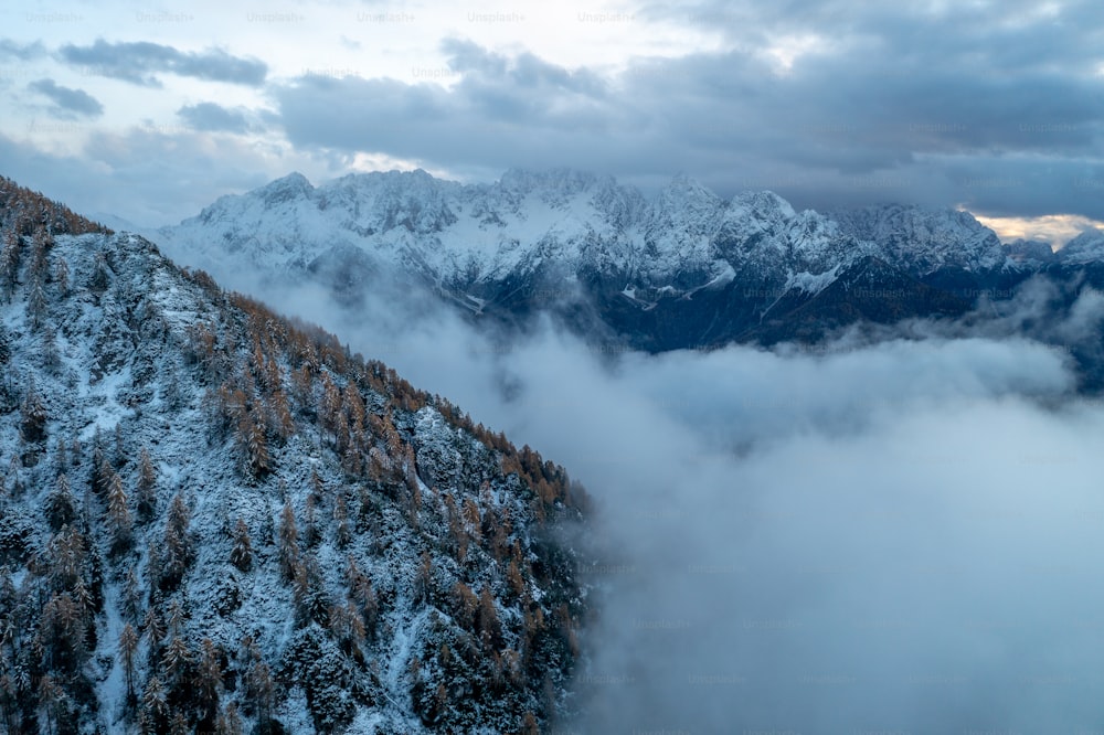 Ein schneebedeckter und von Wolken umgebener Berg