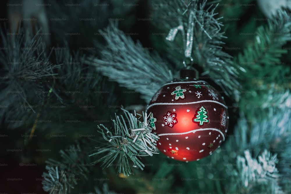 a red ornament hanging from a christmas tree