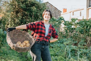 uma mulher segurando uma cesta cheia de batatas