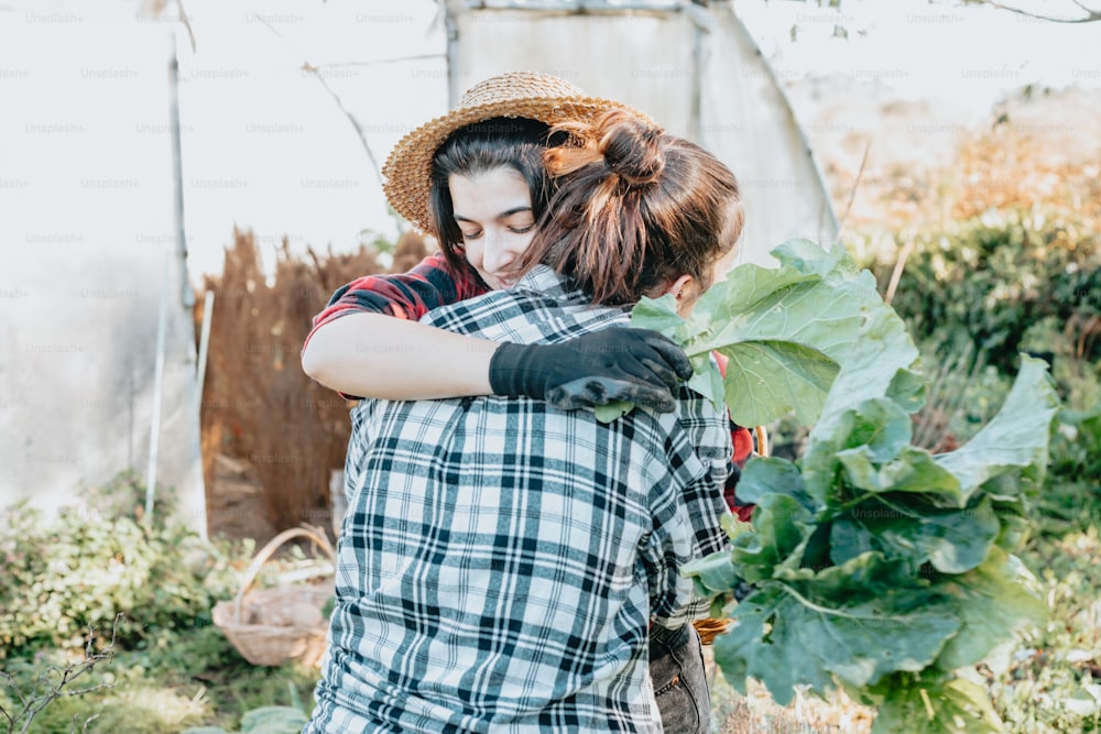 Eine Frau, die eine andere Frau in einem Garten umarmt
