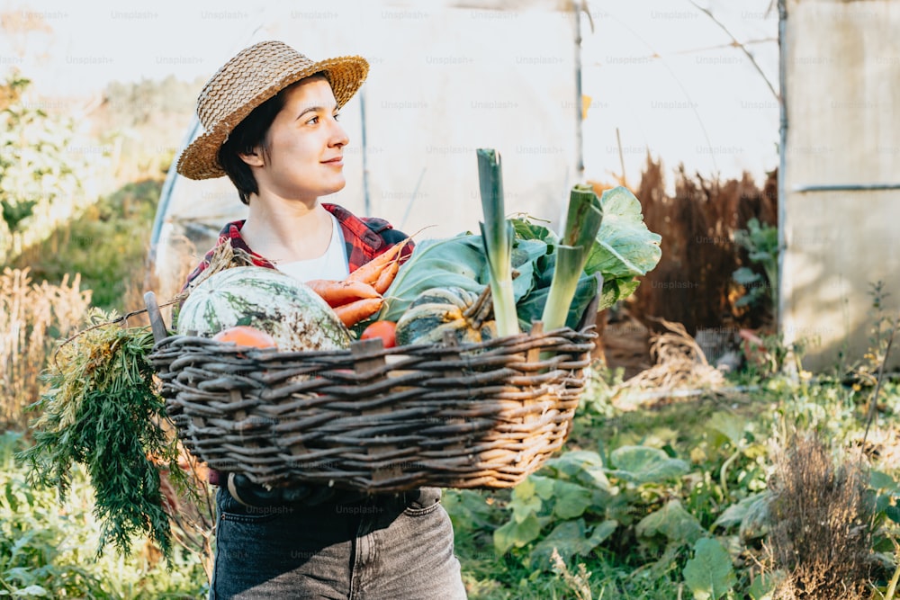 Una donna che trasporta un cesto di verdure in un giardino