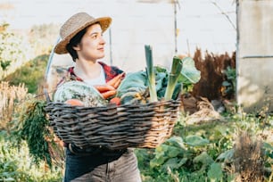a woman carrying a basket of vegetables in a garden