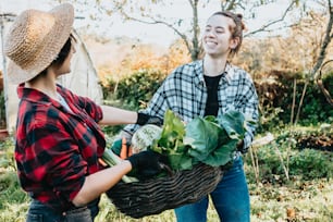 a woman holding a basket full of vegetables next to another woman