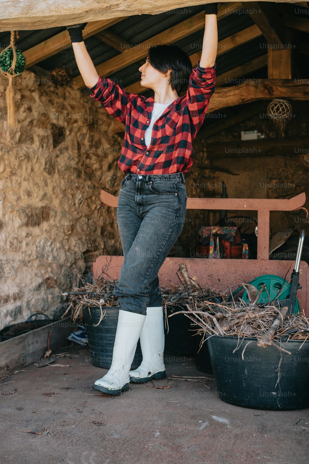a woman in a red and black checkered shirt and white boots