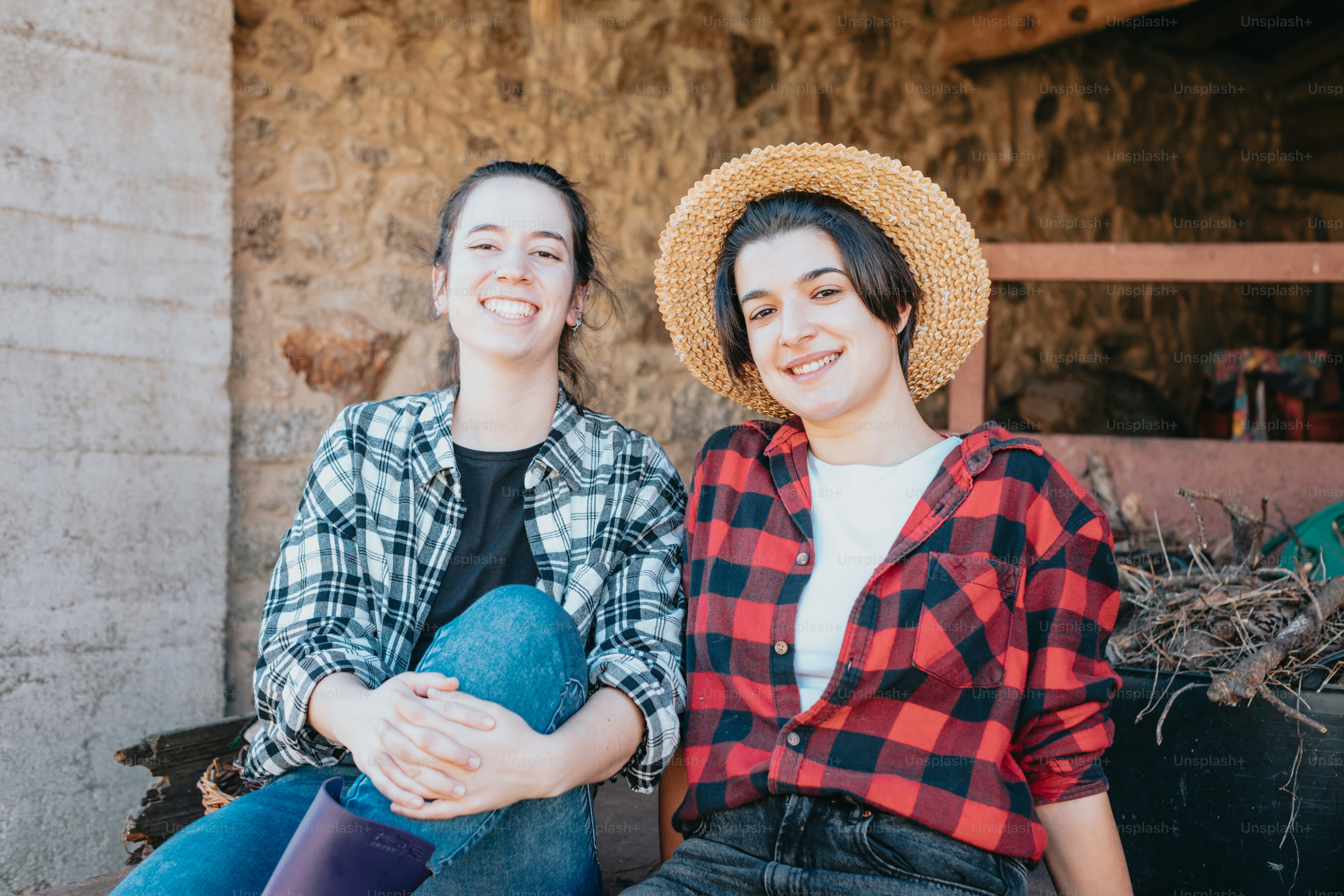 two women sitting next to each other wearing hats