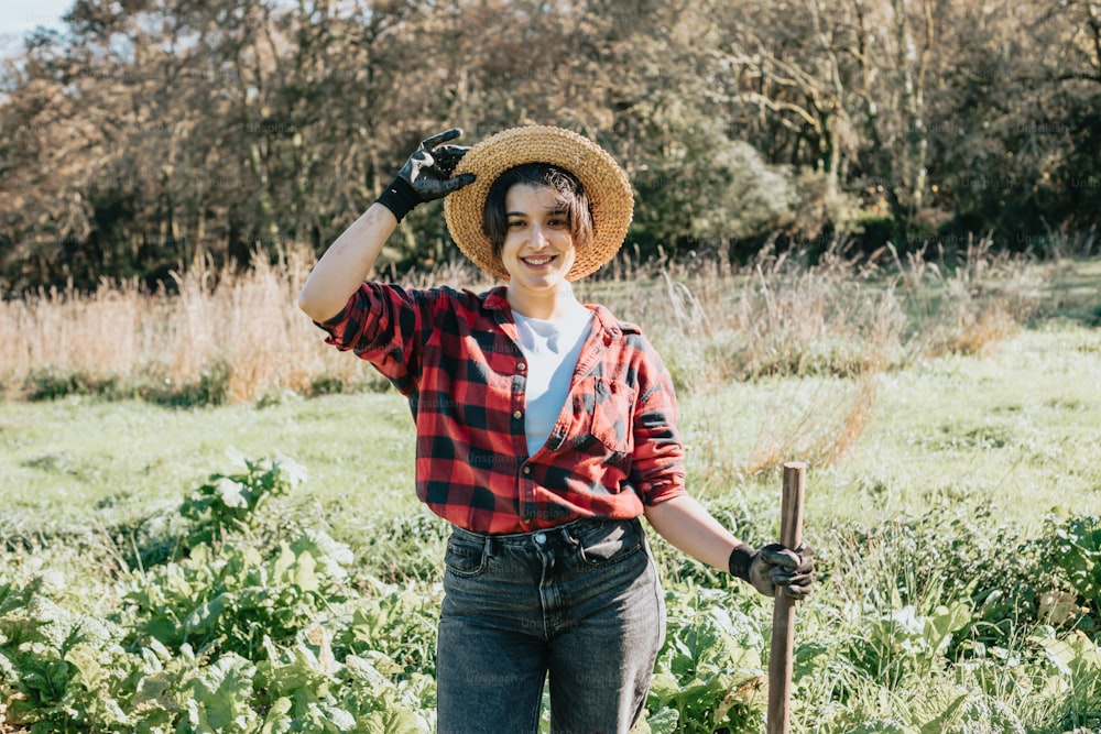Una mujer parada en un campo sosteniendo un palo