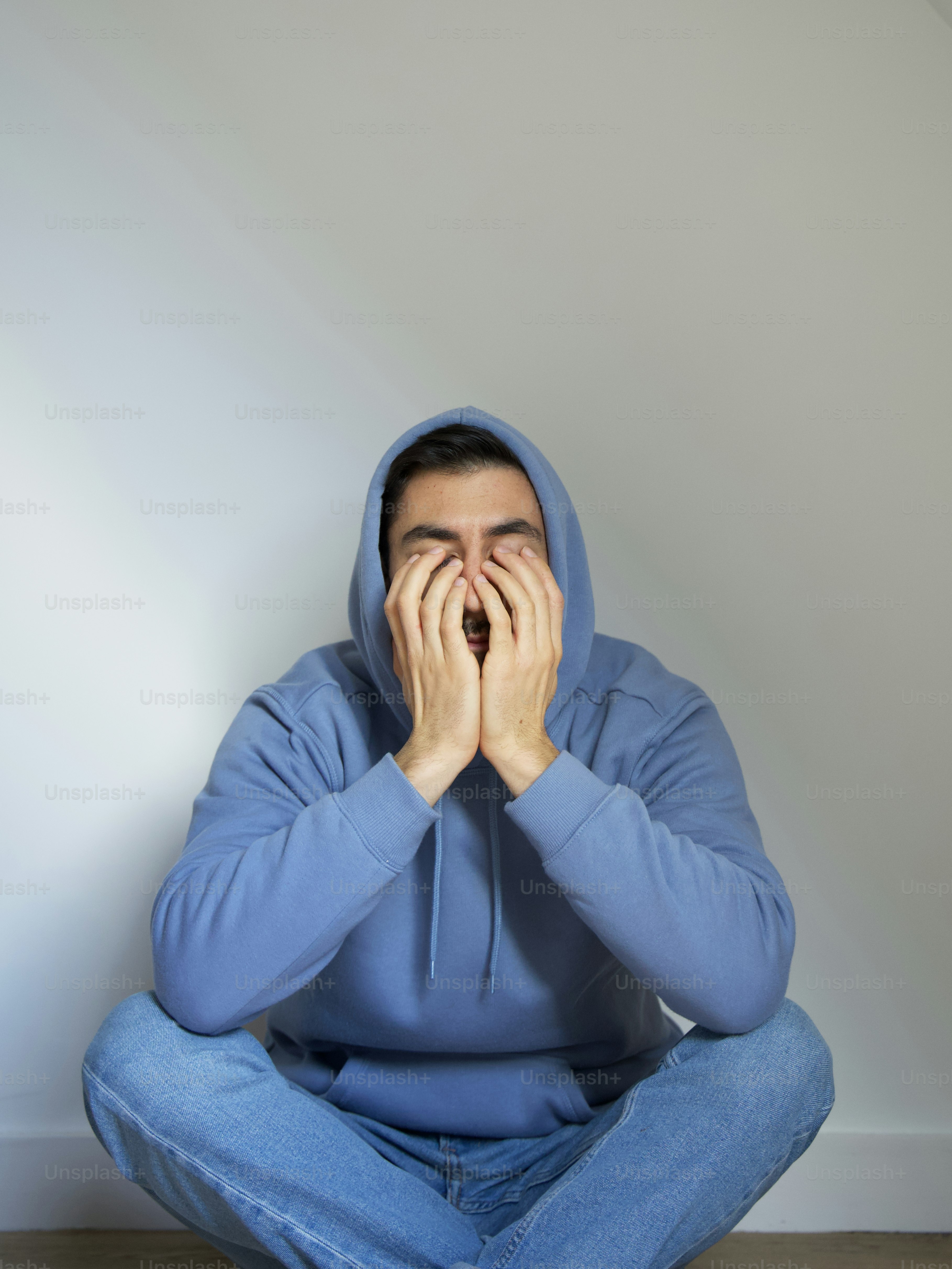 a person sitting with their hands on their face