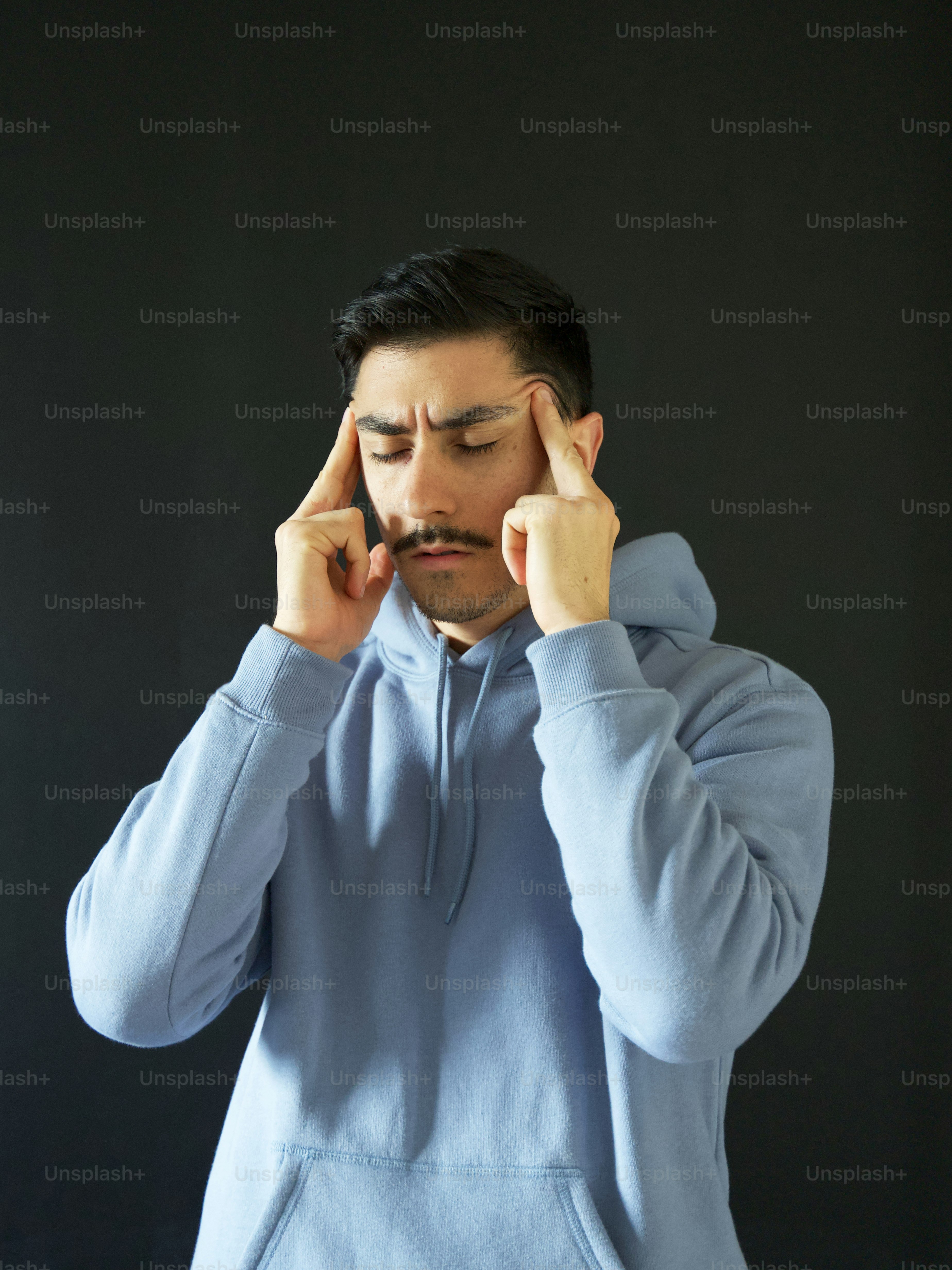 a man holding his hands to his face