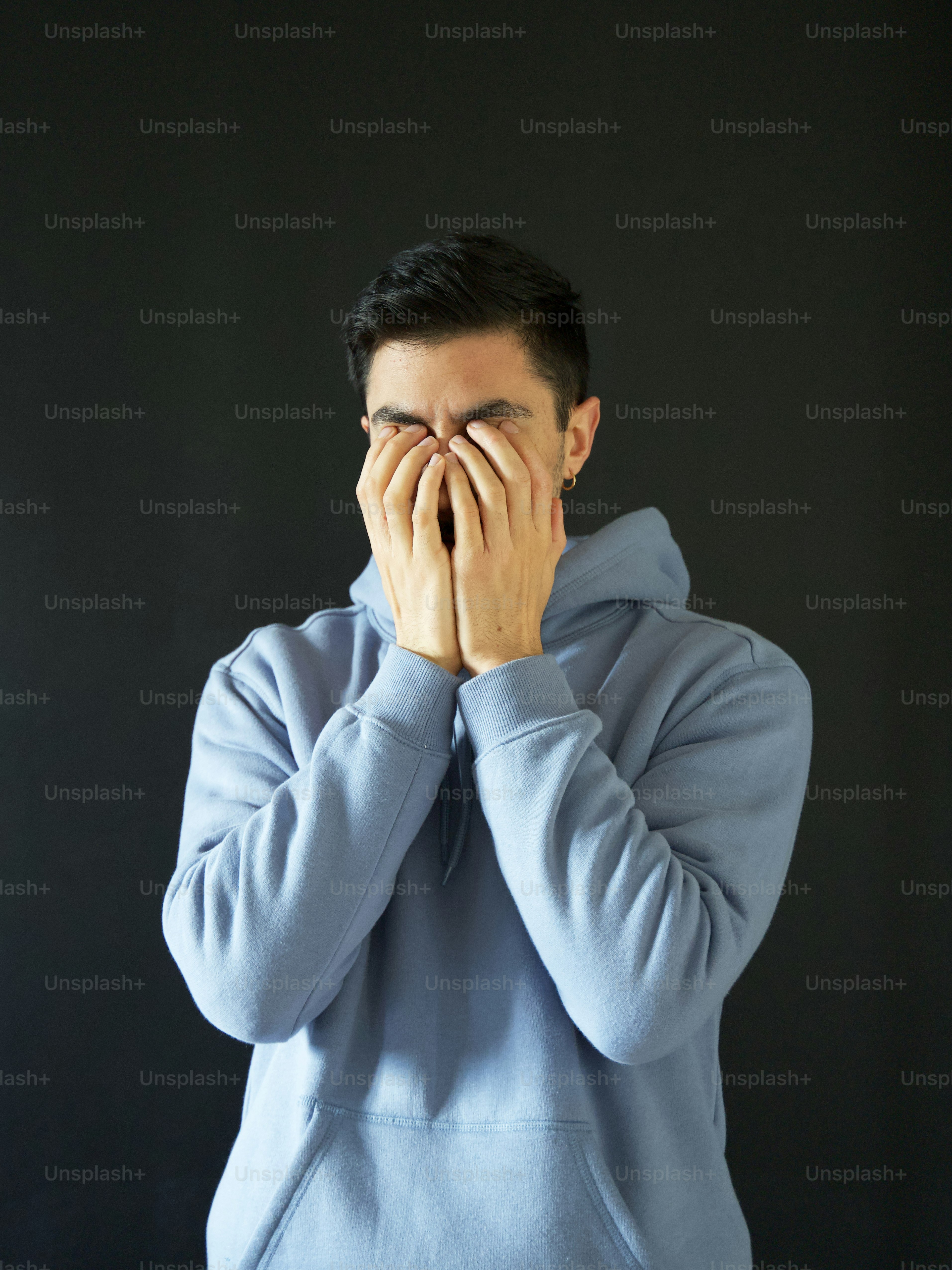 a man holding his face