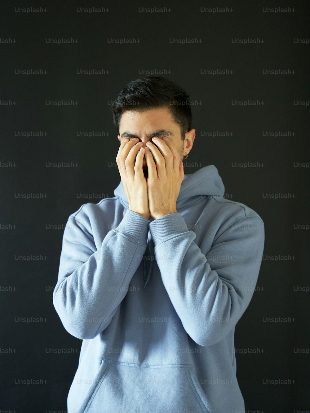 a man holding his face
