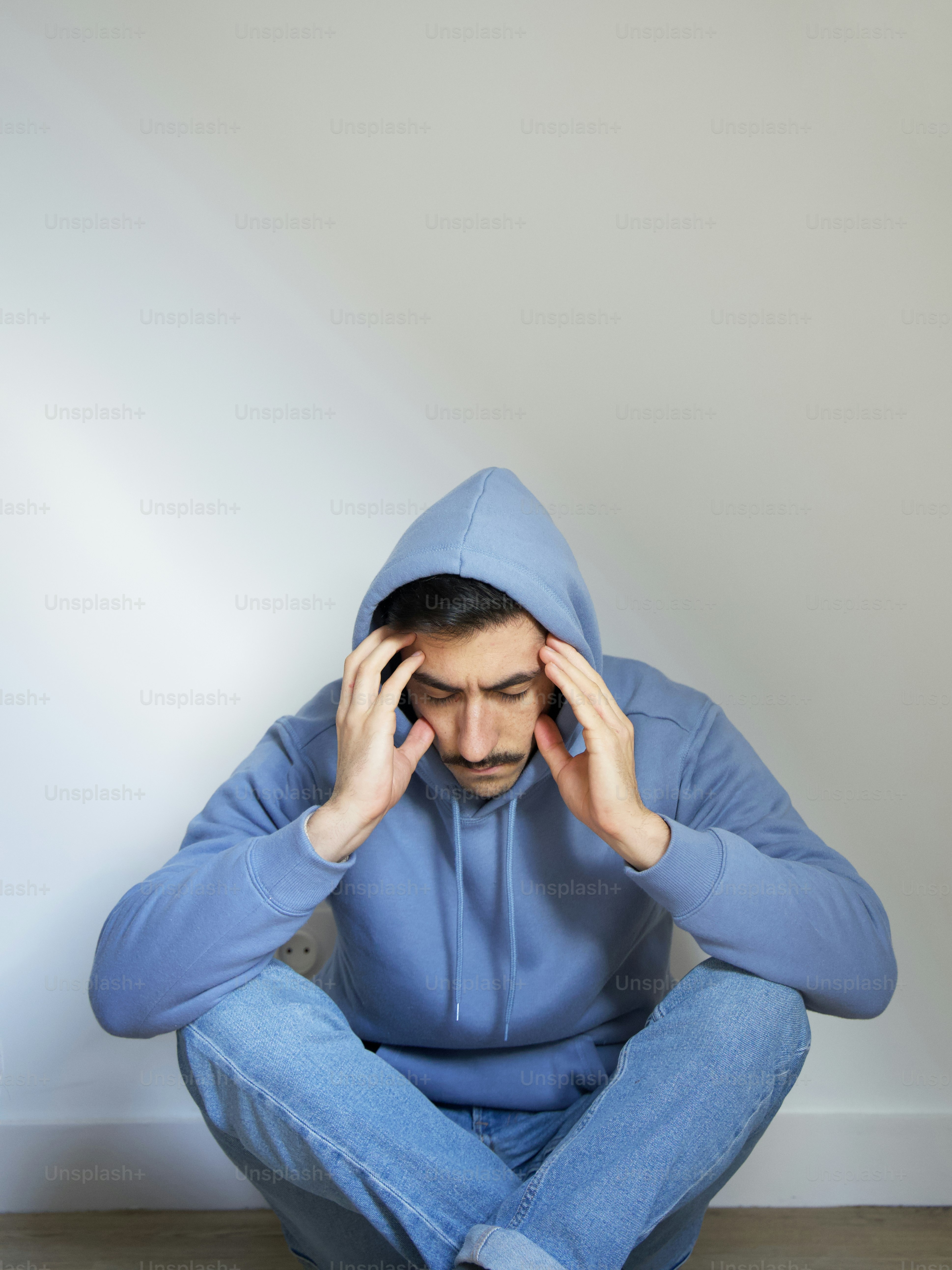 a person sitting on the floor with the hands on the face