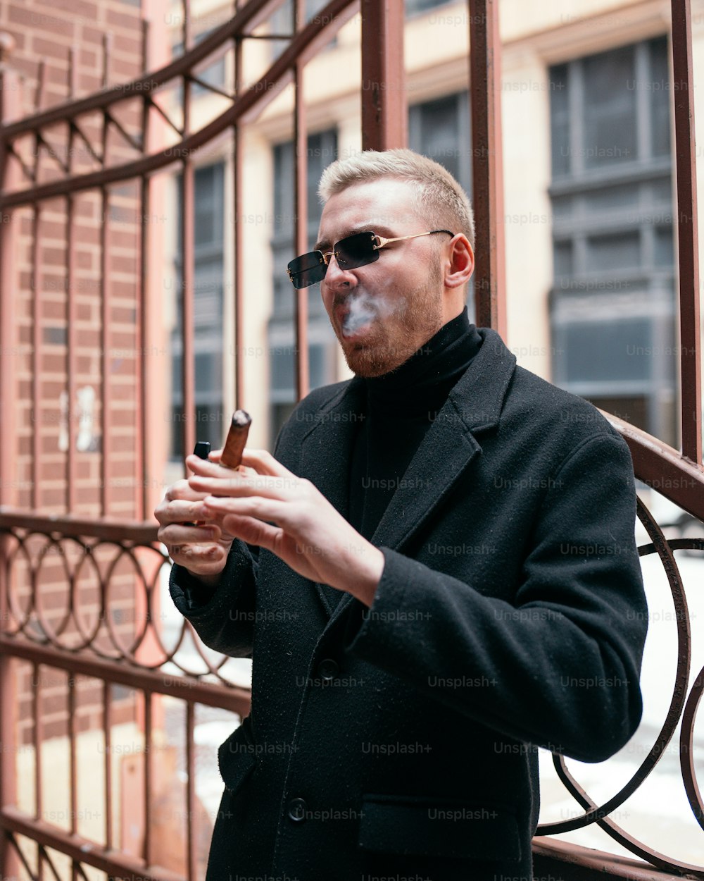 Ein Mann in einem schwarzen Mantel, der eine Zigarette raucht