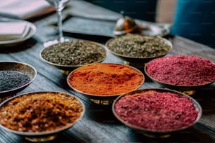 a table topped with bowls filled with different types of spices