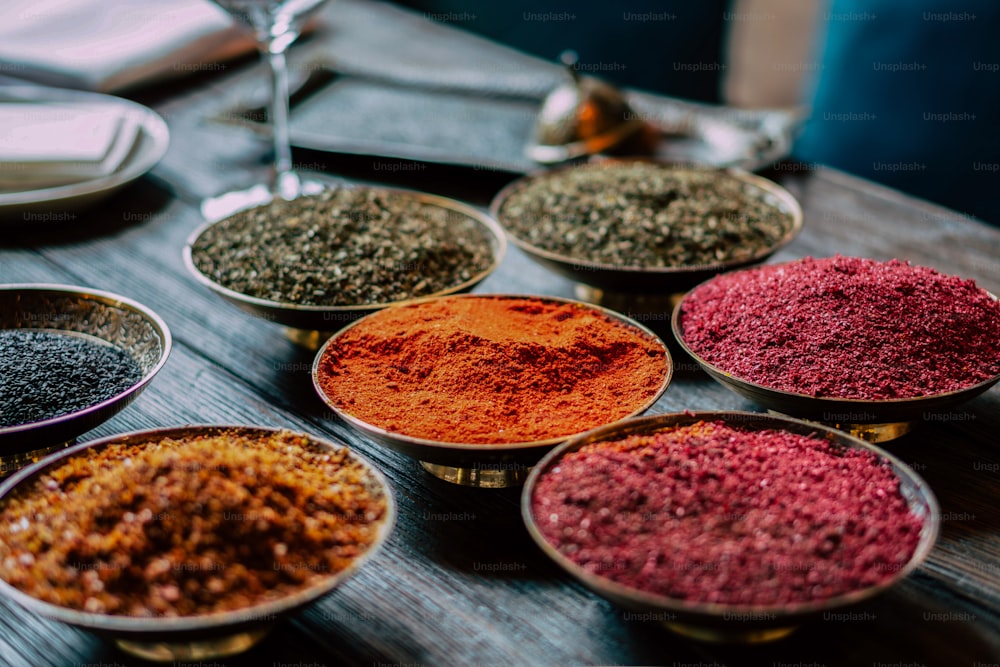 a table topped with bowls filled with different types of spices