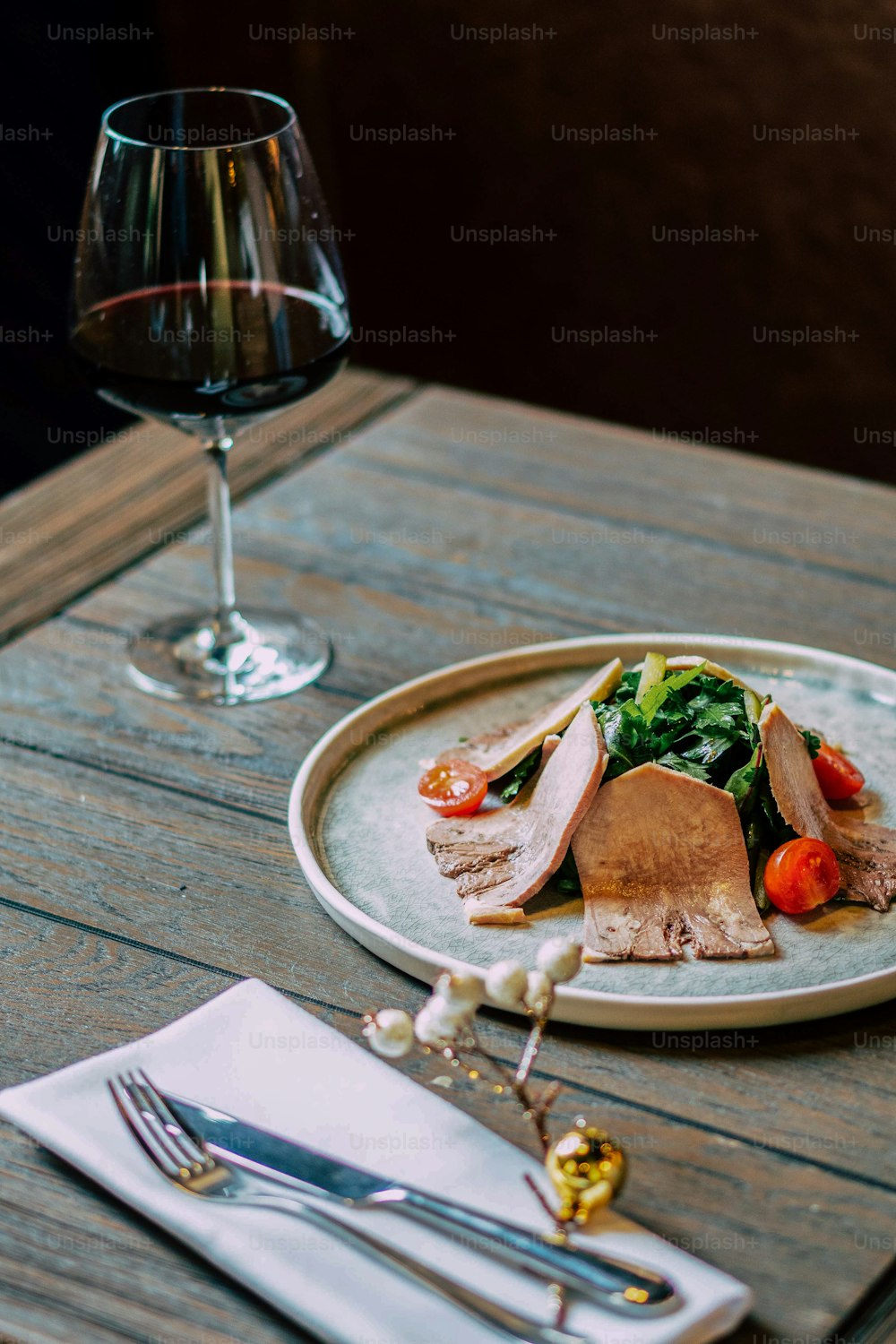 a plate of food and a glass of wine on a table