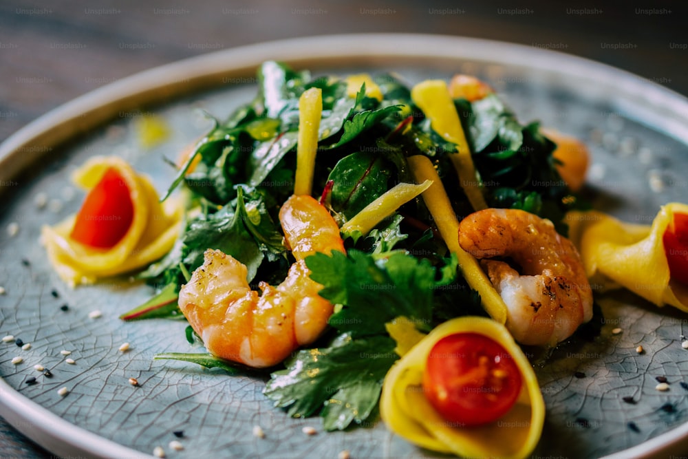 Un plato de pasta con camarones y verduras