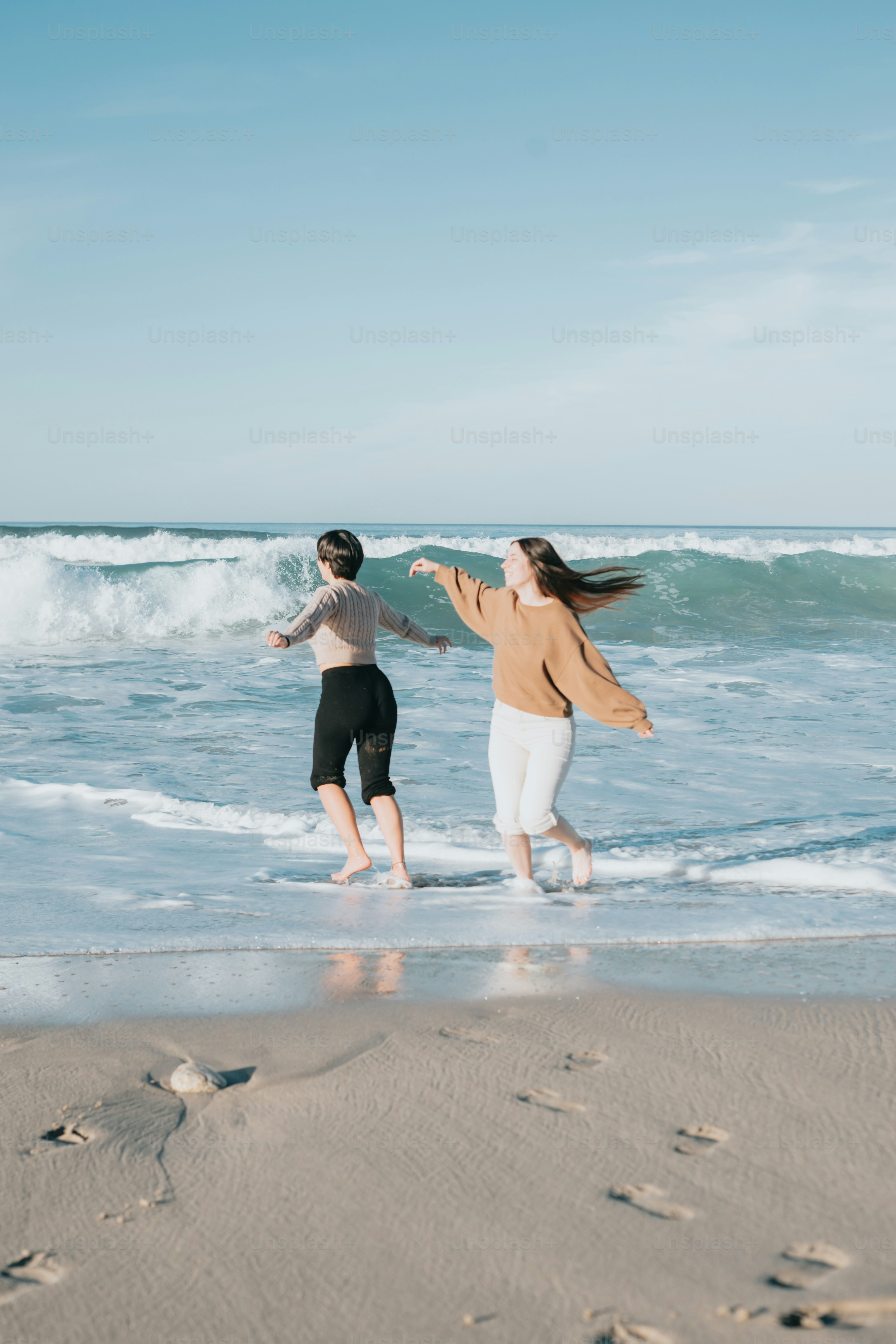 a couple of people that are standing in the sand