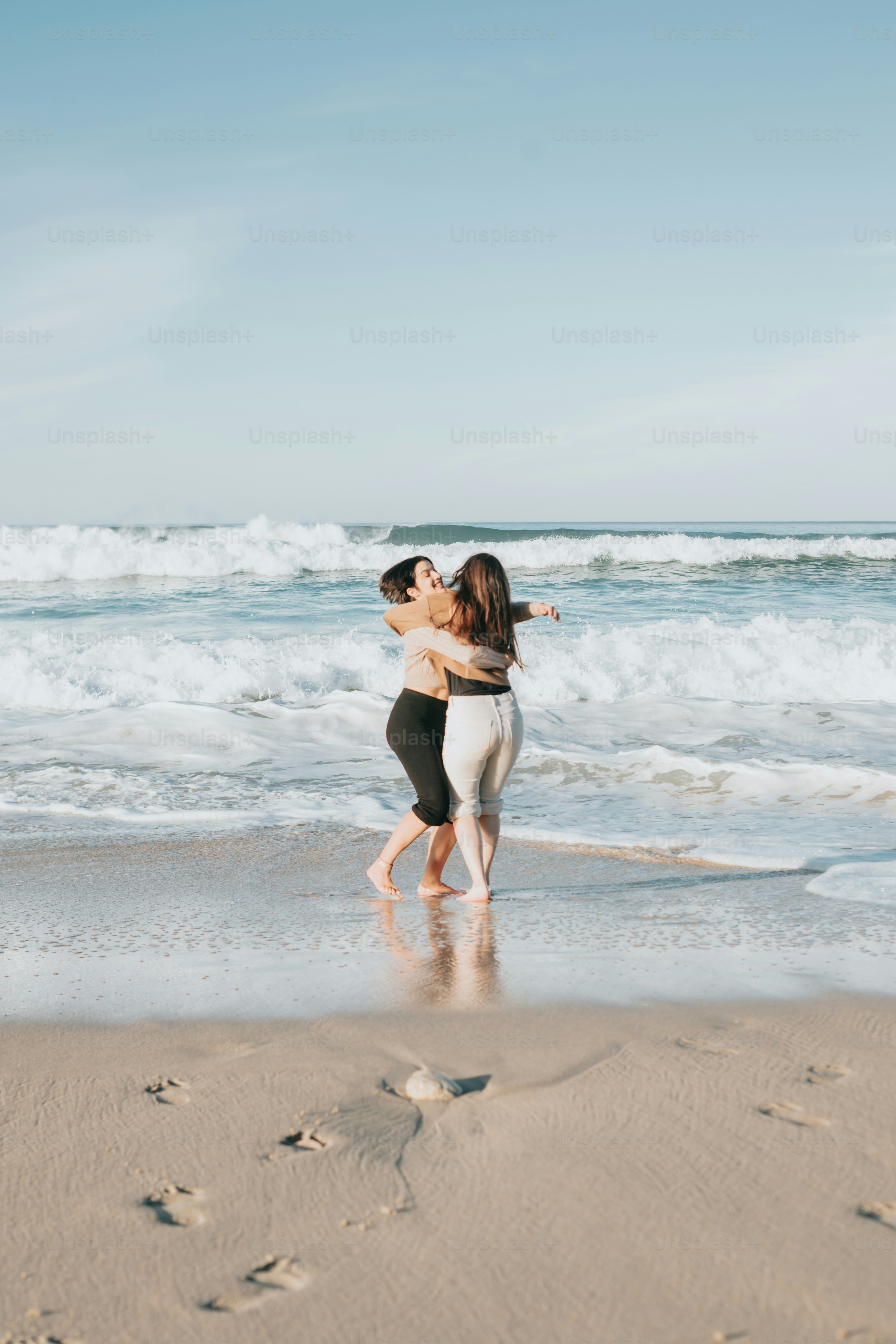 a couple of people that are standing in the sand