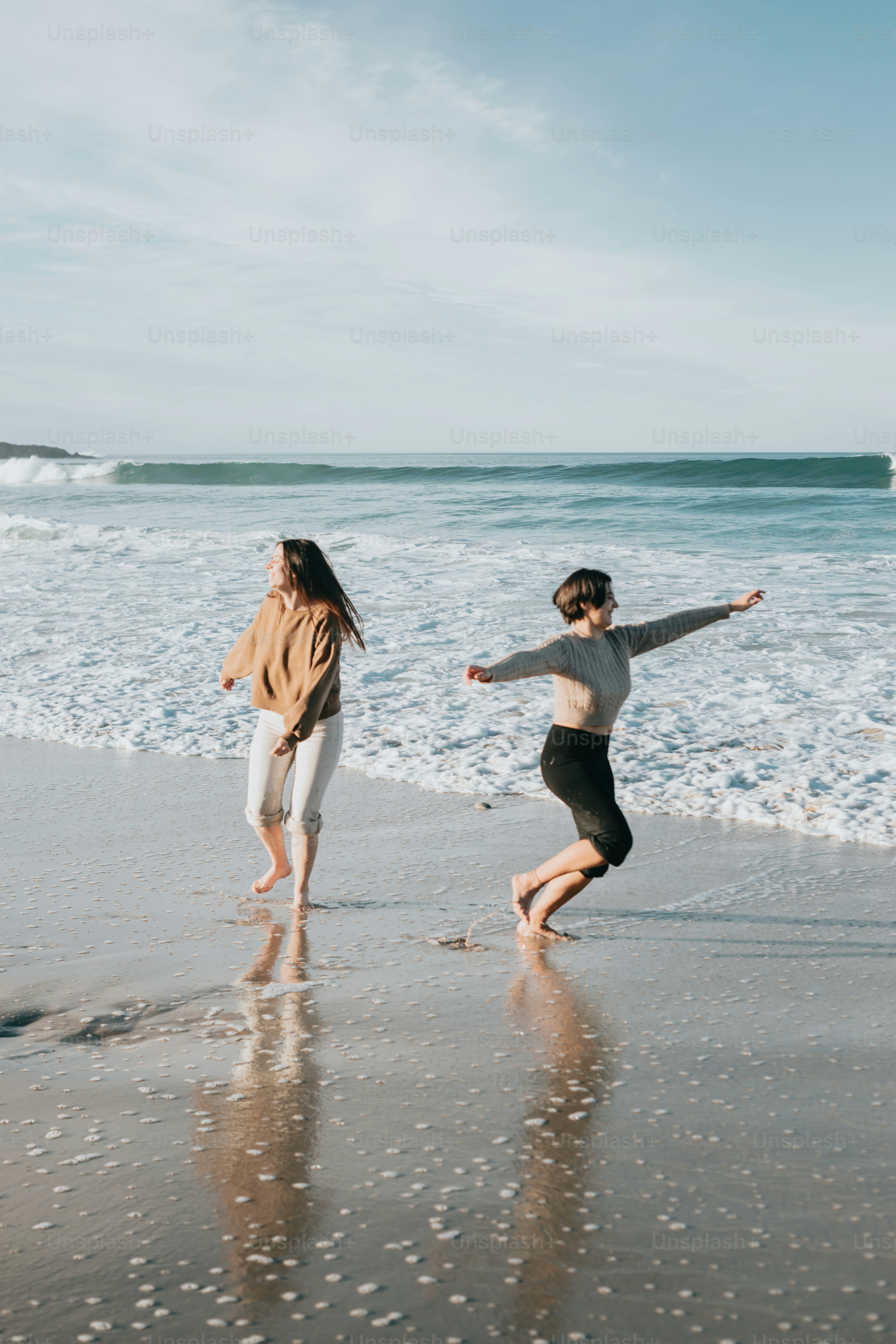 a couple of people that are running on a beach