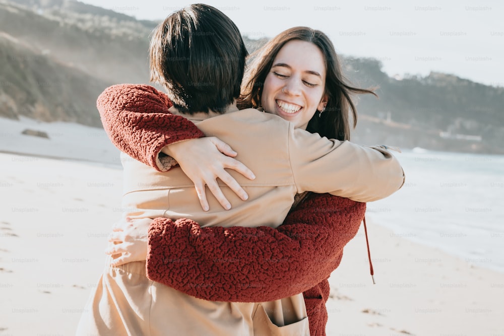 uma mulher abraçando outra mulher na praia
