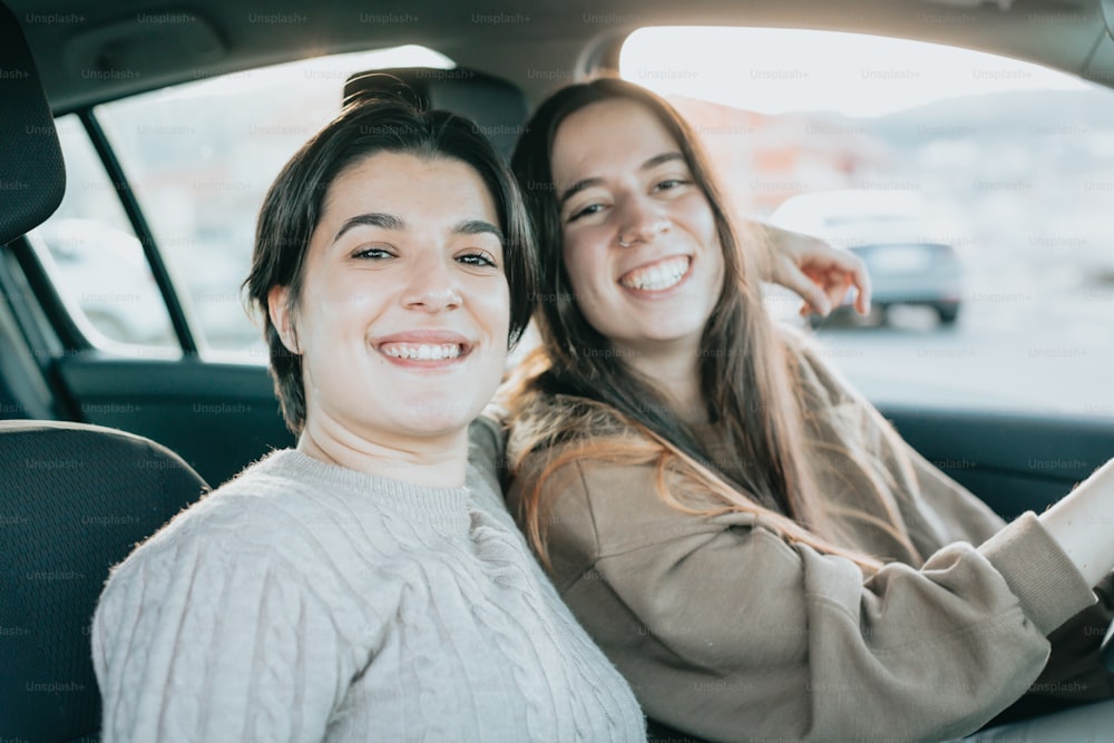 two women sitting in the back seat of a car