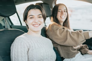 two women sitting in the back of a car