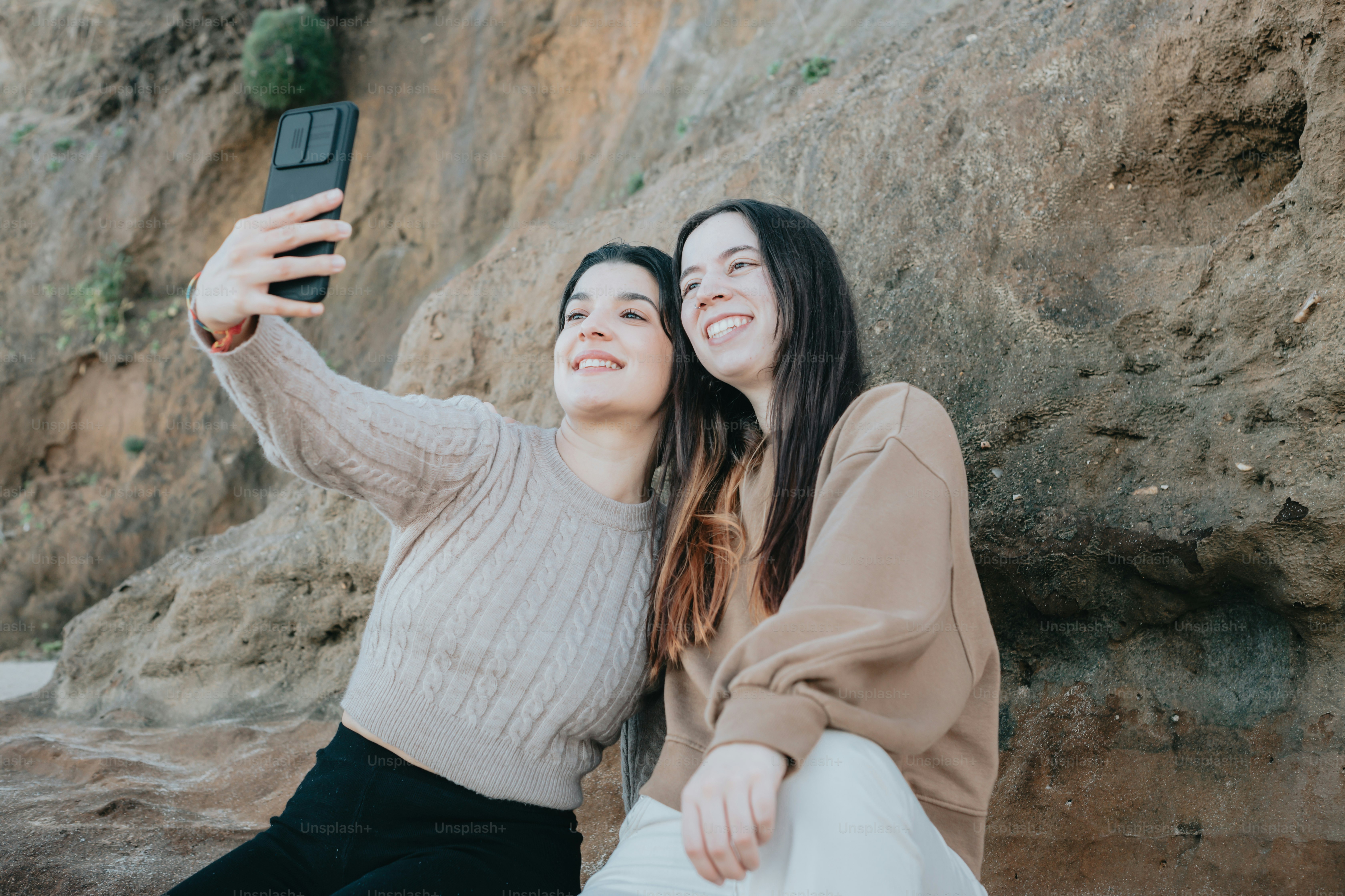 two women taking a picture with a cell phone