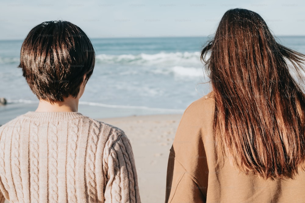 a couple of people standing on top of a beach