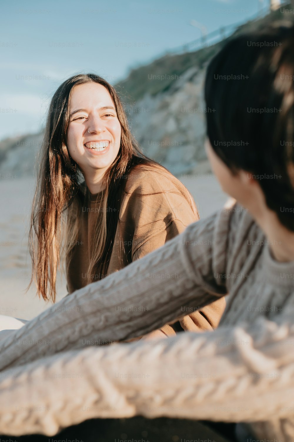 Una mujer sentada junto a otra mujer en una playa