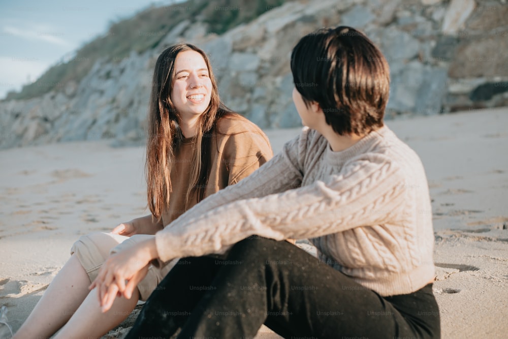 모래 사장 위에 앉아 있는 두 명의 여성