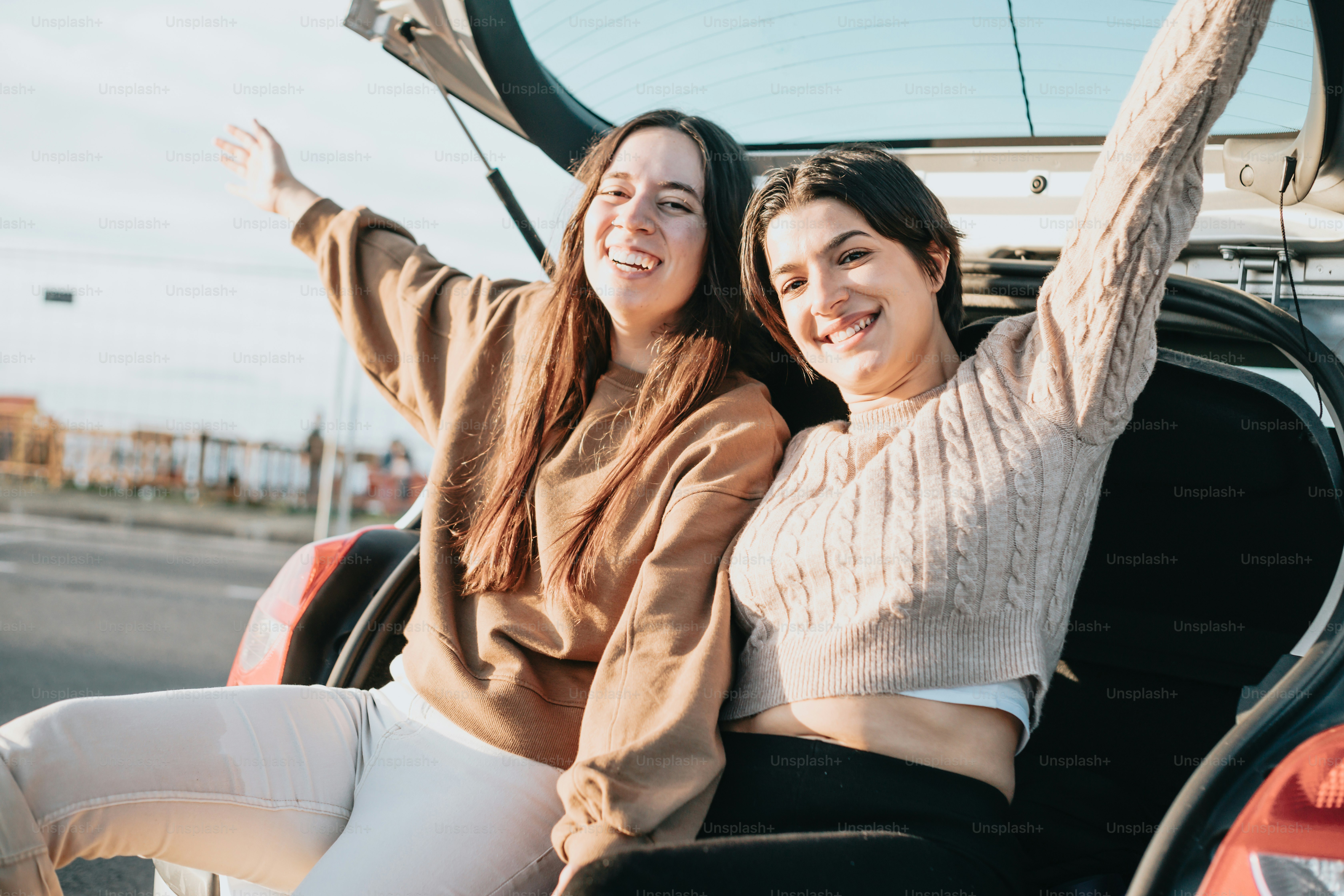 two women sitting in the back of a car