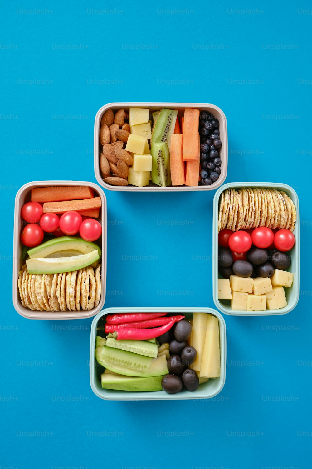 vier Plastikbehälter, gefüllt mit verschiedenen Arten von Lebensmitteln