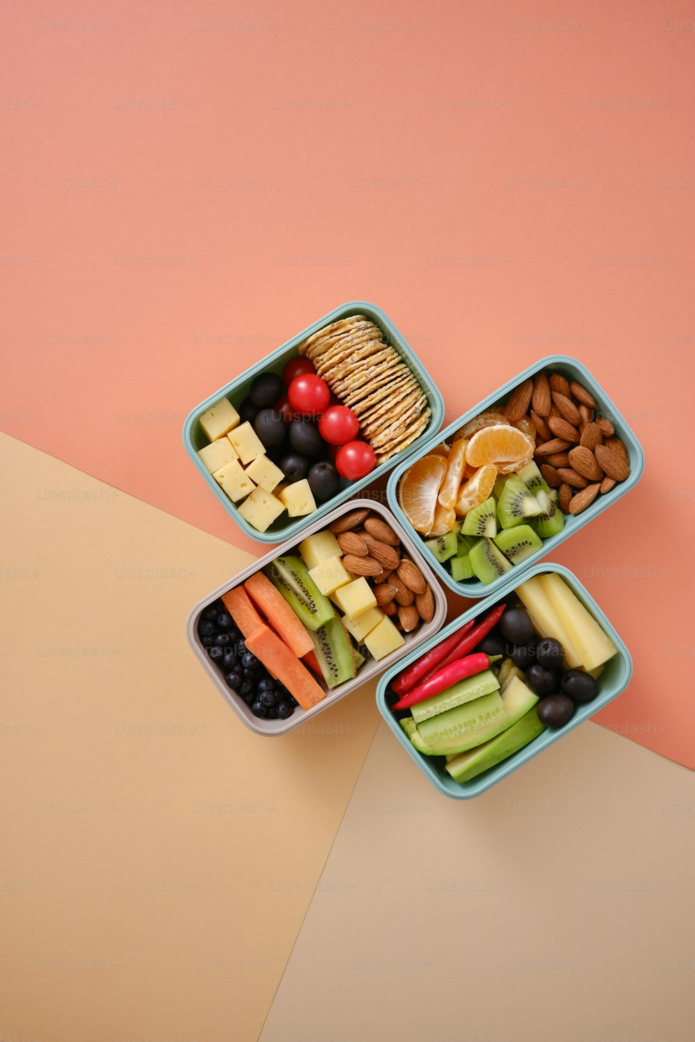Cuatro recipientes de plástico llenos de diferentes tipos de alimentos
