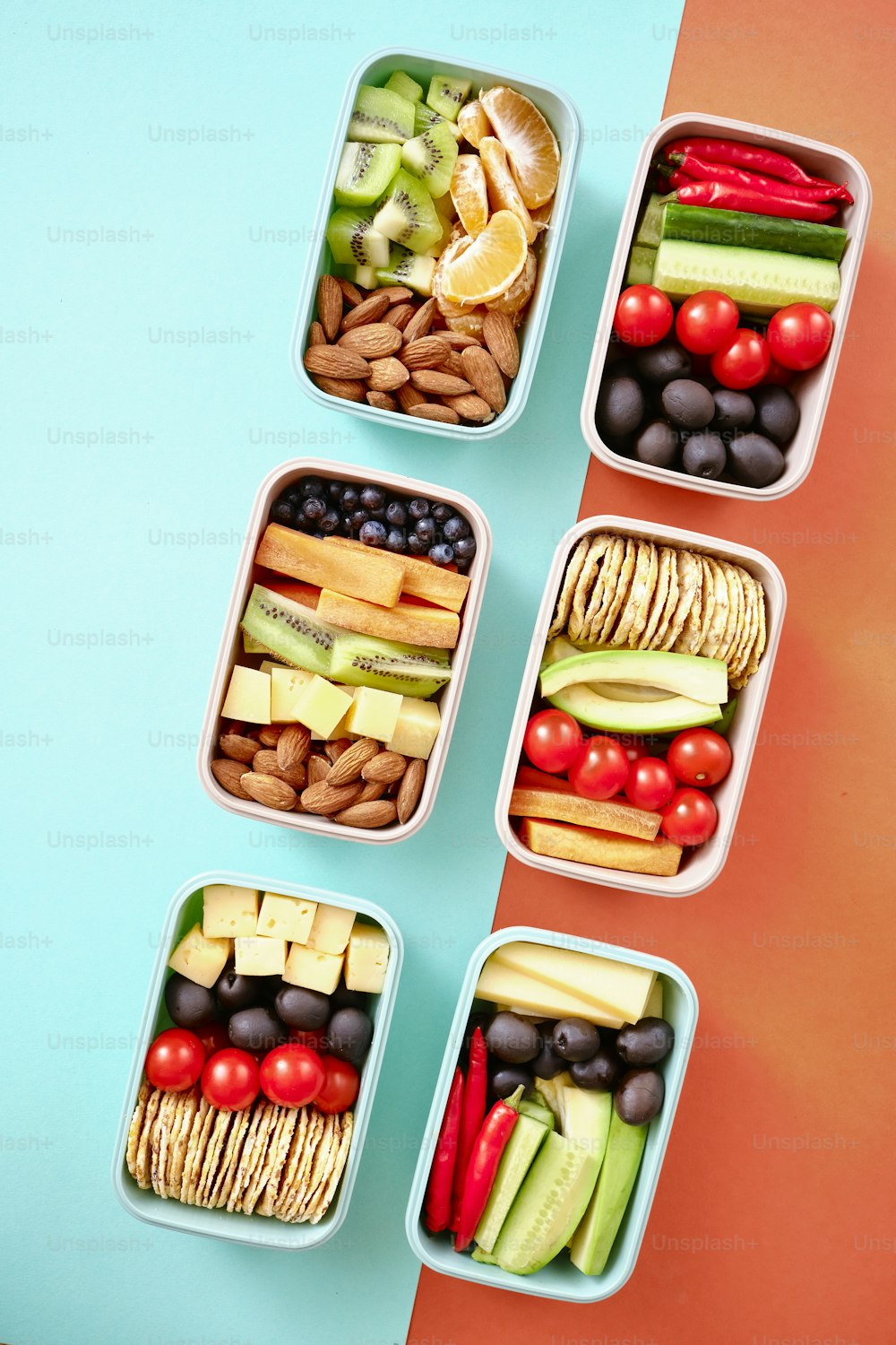 Cuatro recipientes de plástico llenos de frutas y verduras variadas