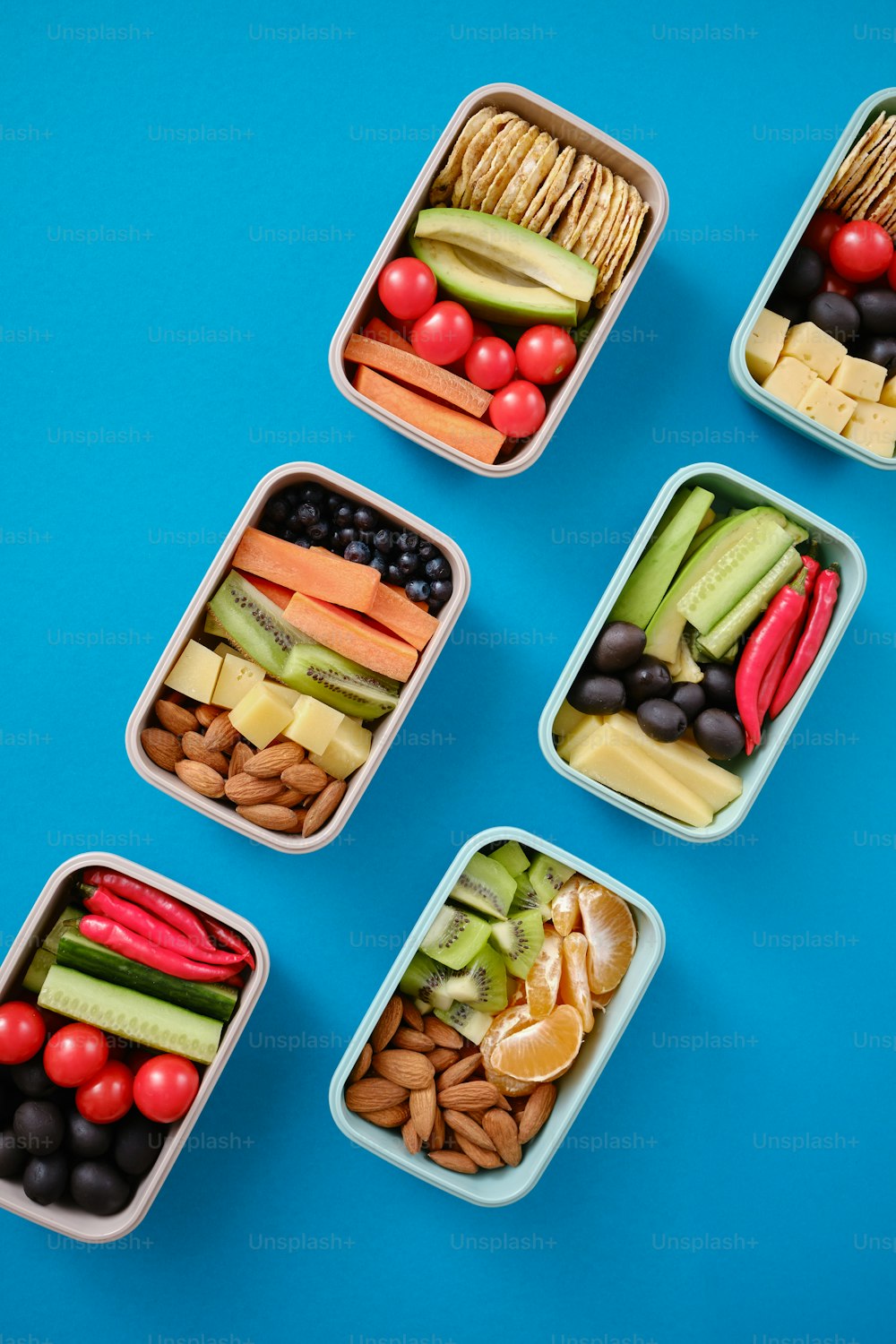 quatro recipientes plásticos cheios de diferentes tipos de alimentos