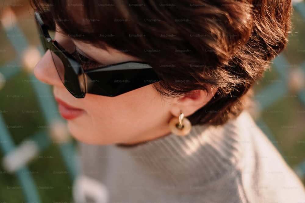 Una mujer con un par de gafas de sol y un suéter